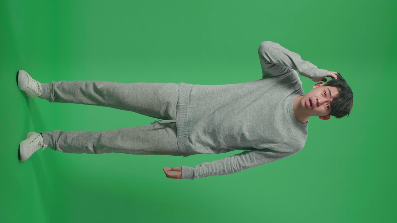 Full Body Of Puzzled Asian Man Is Standing In Front Of Green Screen Background