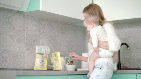 mother preparing food for little baby at kitchen. mother care child