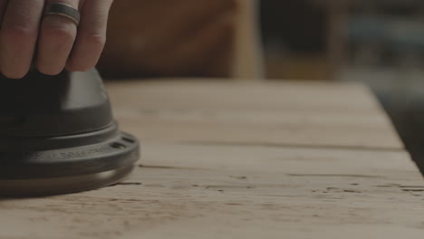 a person is sanding a plank of wood