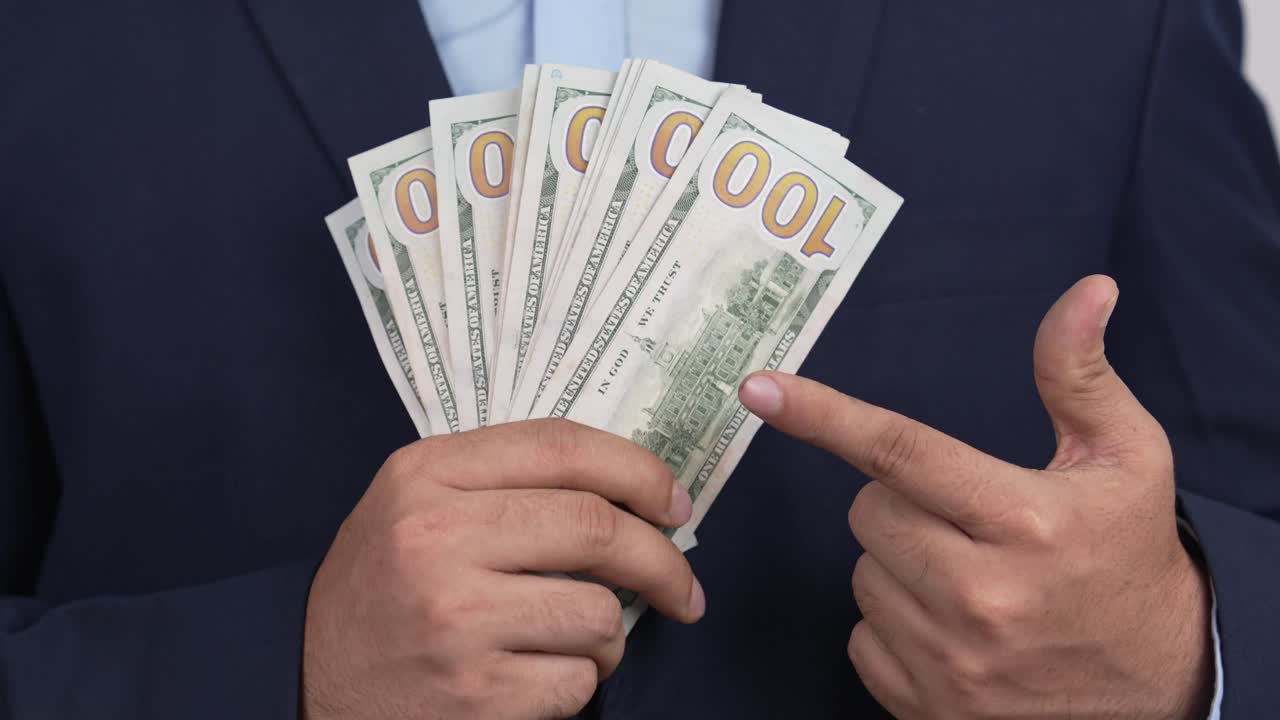 Homem mostrando maço de notas de dólar americano, conceito de riqueza e renda, Vídeo 4K