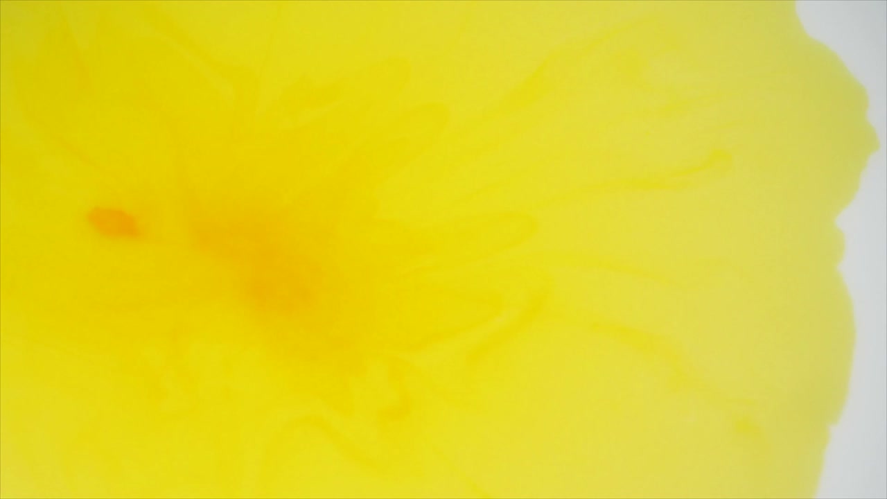 Goccia di Liquido Giallo che si Mescola e si Diffonde in un Fluido Bianco