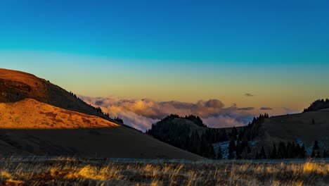 Farbenfroher-Sonnenuntergang-über-Der-Bergkette-Mit-Dicken-Weißen-Wolken,-Die-Herumwirbeln