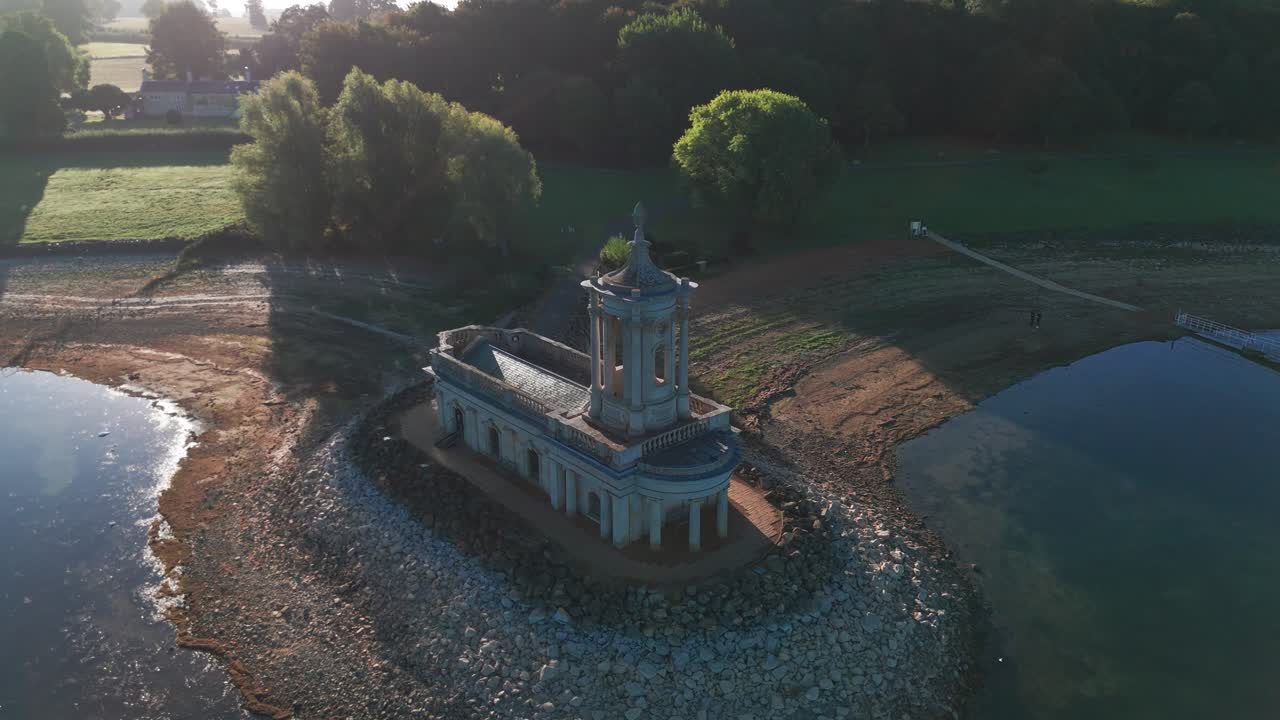 Aerial view of Normanton Church surrounded by water at sunrise