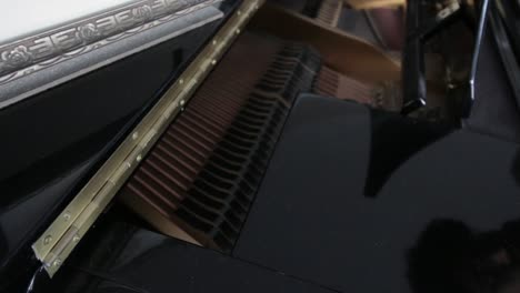 shot looking into a piano, showing off the strings while the instrument is being played