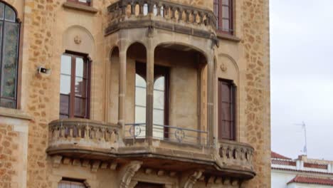 edificio arquitectónico de fachada de piedra con ventanas altas y balcones