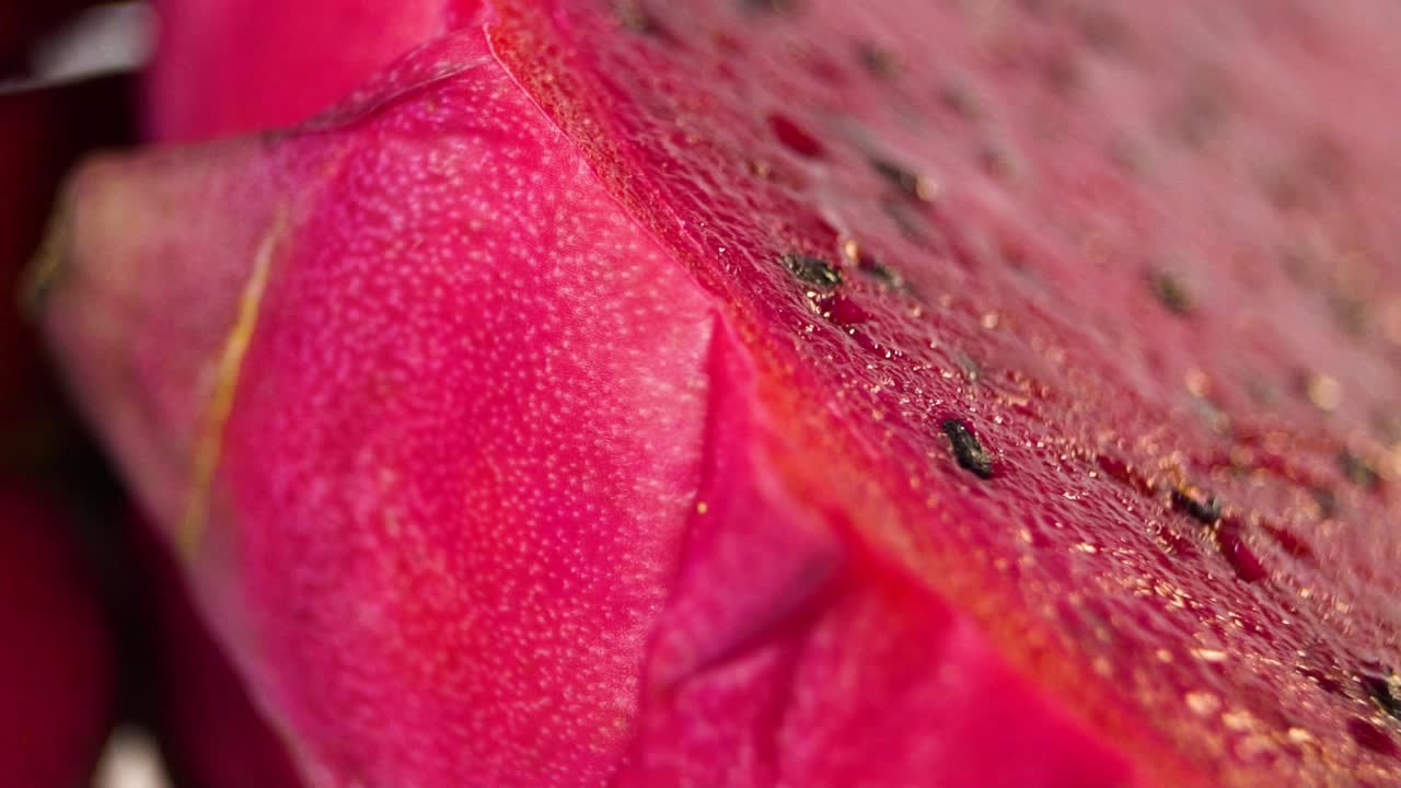 반으로 자른 드래곤 과일의 슬로우 모션 회전 샷으로 육즙이 많은 내부와 많은 씨앗이 드러납니다.
