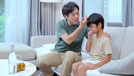 a father cares for his unwell child in a bright, cozy living room, checking temperature and offering comfort