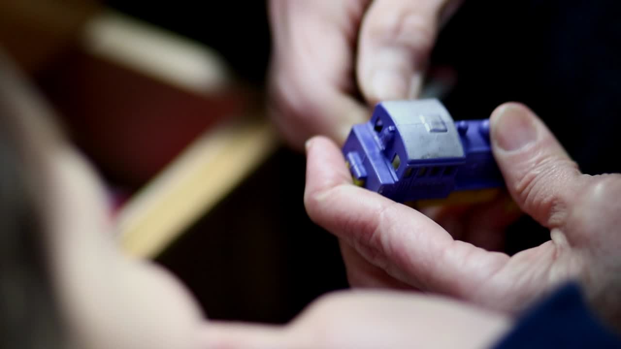 adulto enrollando un juguete mecánico infantil vintage para un niño pequeño divertido: niño, juguetes de acción de cuerda