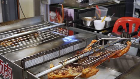 un cerdo y otros alimentos giran en un saliva rotisserie en un restaurante