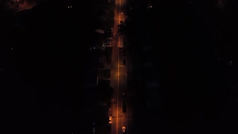 orange lighting street with lanterns and driving car. aerial top down tracing shot. traffic on street. quiet serene atmosphere in america.