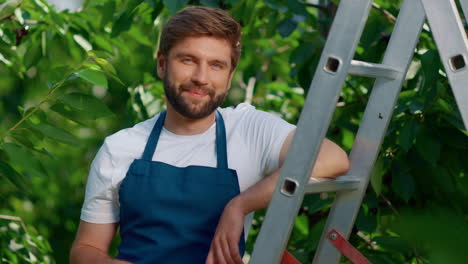 Hombre-Propietario-De-Agronegocios-Sonriendo-árboles-Verdes-En-Cálidas-Tierras-De-Cultivo-Posando.-Concepto-Agrícola