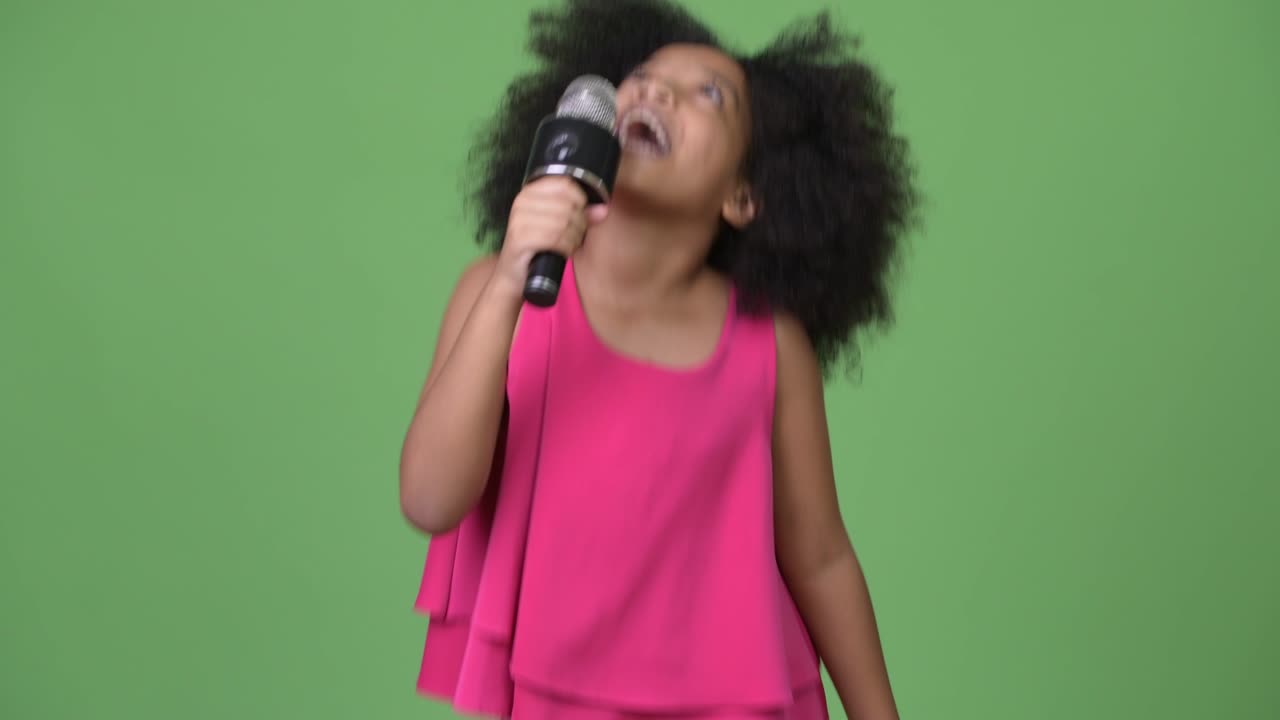 Young cute African girl with Afro hair singing happily