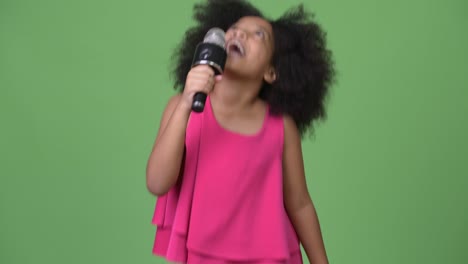 young cute african girl with afro hair singing happily