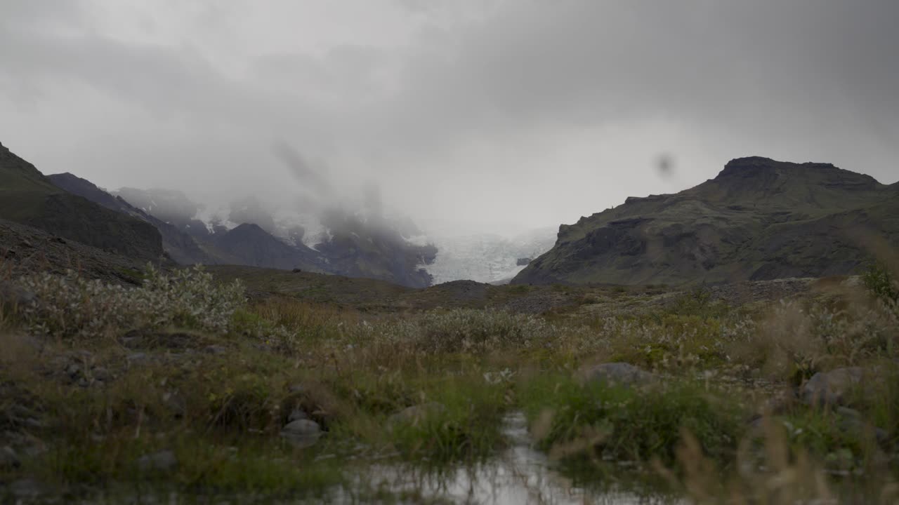 웅장한 아이슬란드 풍경, 구름이 가득한 산, 멀리 있는 빙하