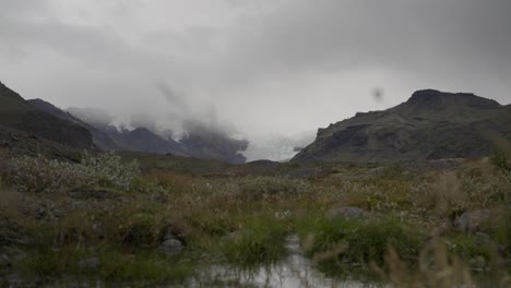 Majestic-Iceland-landscape,-cloudy-mountains,-distant-glacier