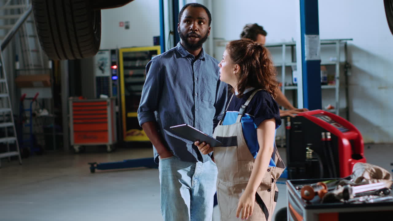 Technician and man look for car parts