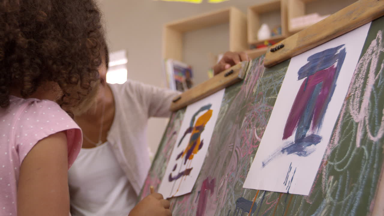 Insegnante di una scuola Montessori che aiuta i bambini a lezione di arte