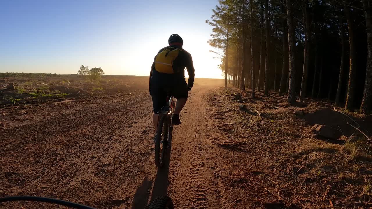 Silhouette di ciclista in bicicletta al tramonto, vista da action camera