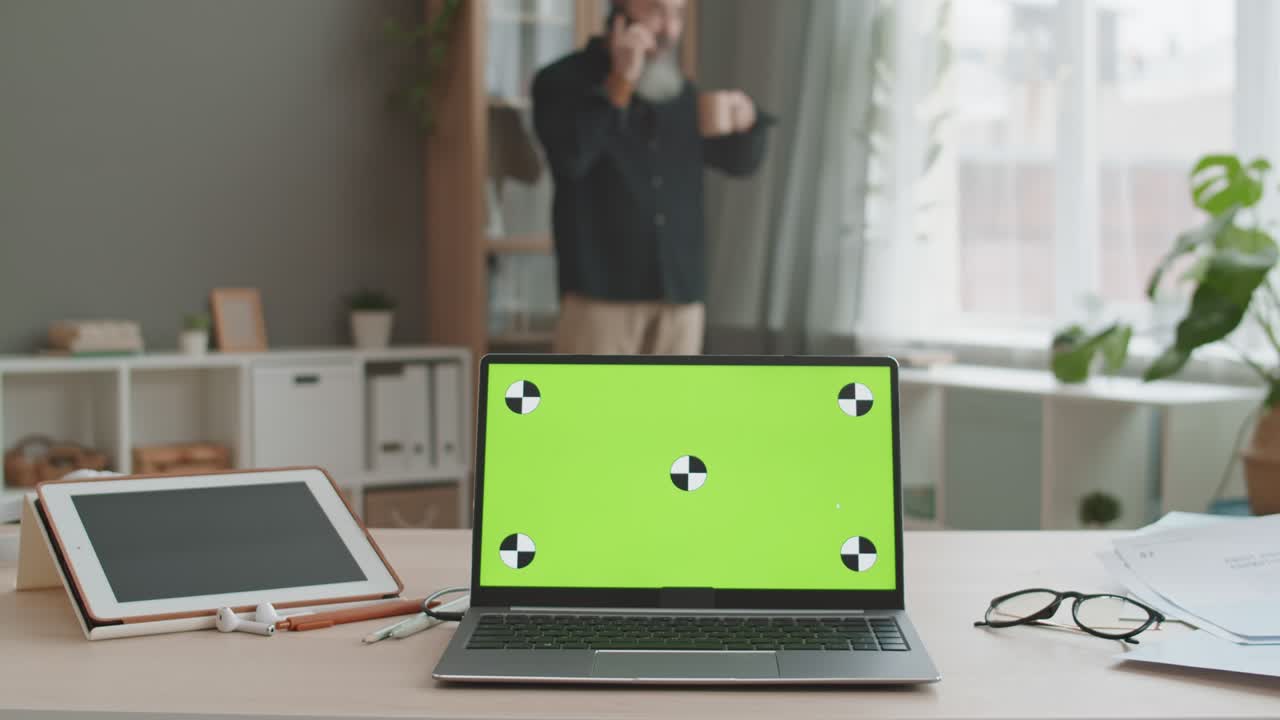 portátil con pantalla verde en el lugar de trabajo