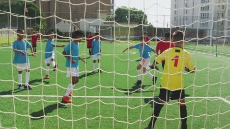 african american kid in red scoring in a sunny day