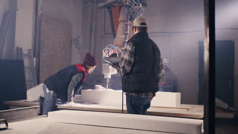 two workers operating a cnc foam cutting machine