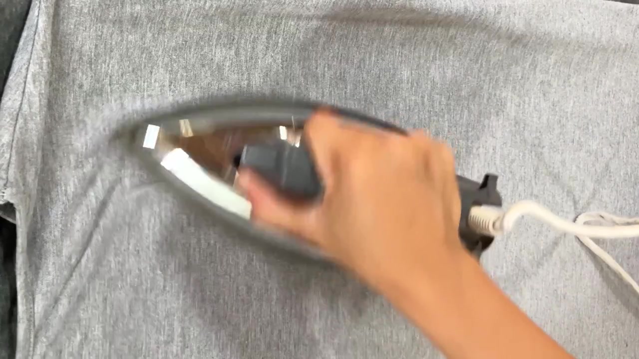 4K close-up of female hands using an iron to smooth fabric. Essential housework, laundry routine, and domestic lifestyle footage.