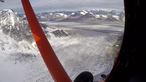 flying over the denali national park in a red airplane