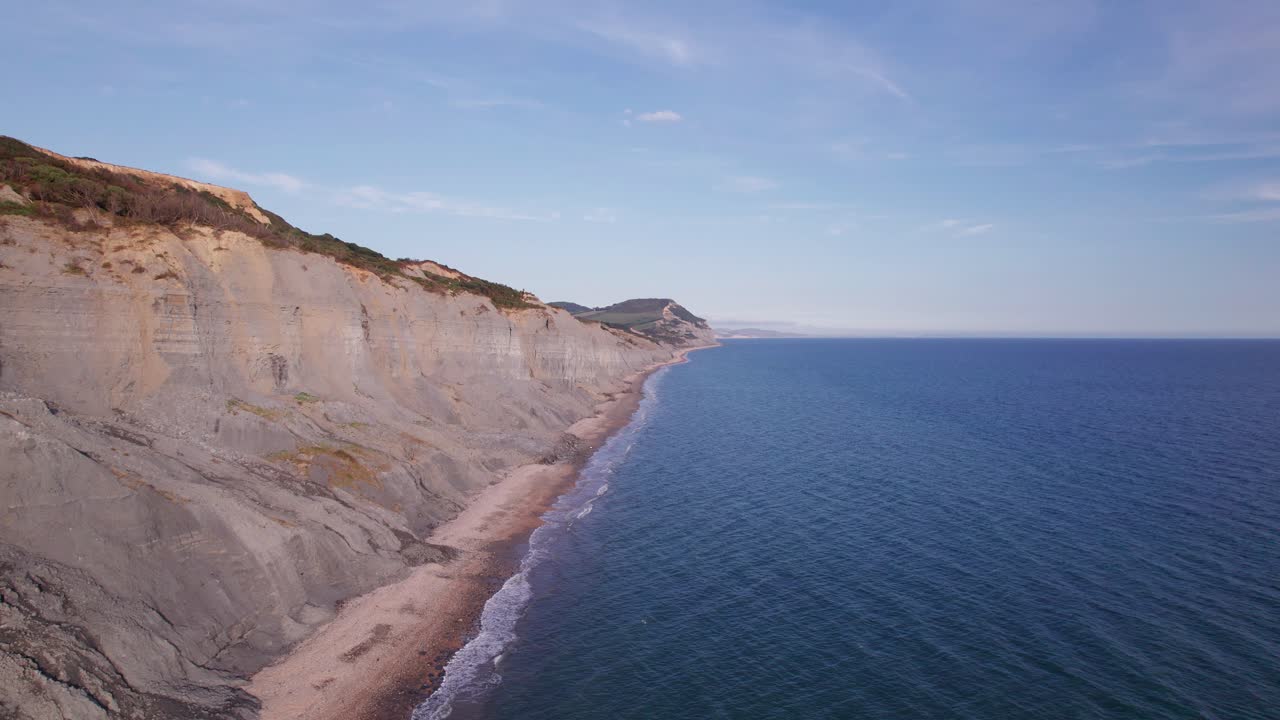 Ripresa aerea con drone in ascesa che mostra le scogliere della Costa Giurassica in una giornata estiva, Dorset, Regno Unito.