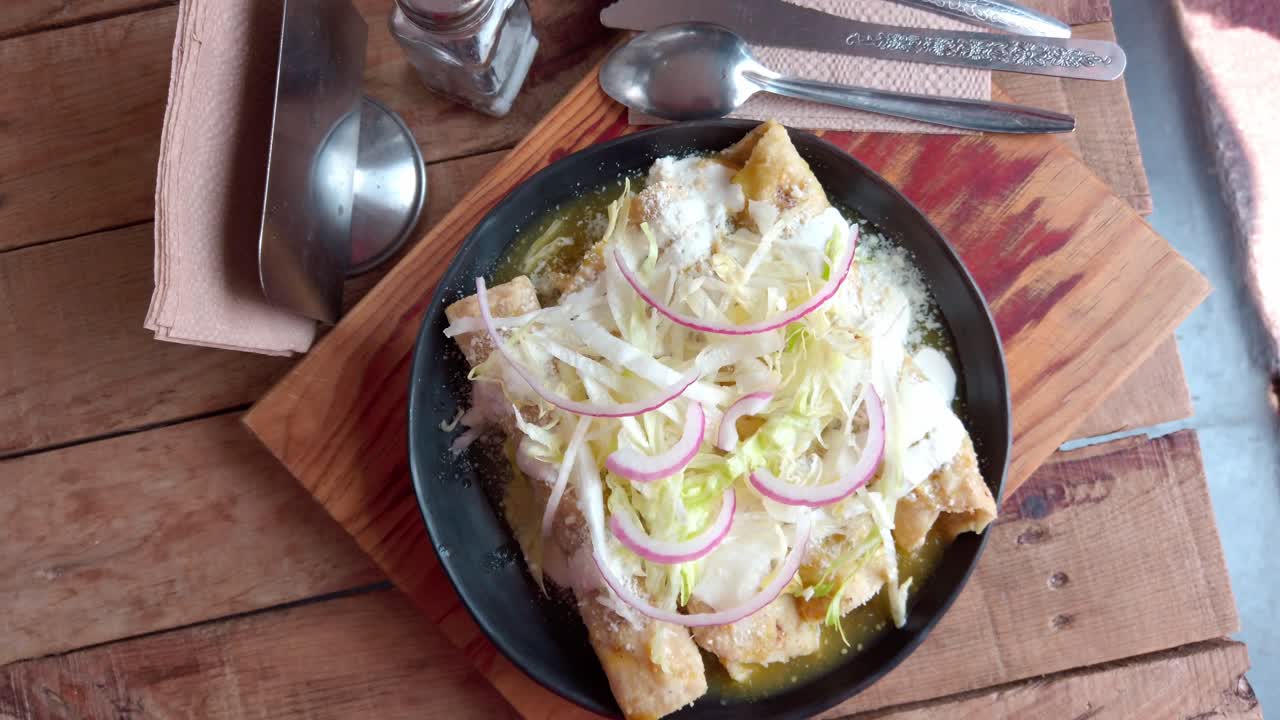 Delicious enchiladas covered with rich mole sauce, topped with shredded lettuce and onion