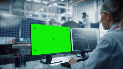 ingeniera utiliza una computadora de pantalla verde para analizar satélites. instalación de fabricación de la agencia aeroespacial: los científicos desarrollan y ensamblan naves espaciales para misiones de exploración espacial. sobre el hombro