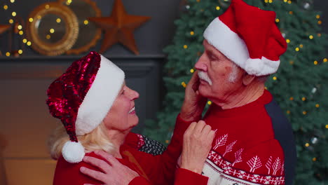 feliz pareja de ancianos de la familia abuela abuela abrazándose y besándose en la habitación de la casa de navidad