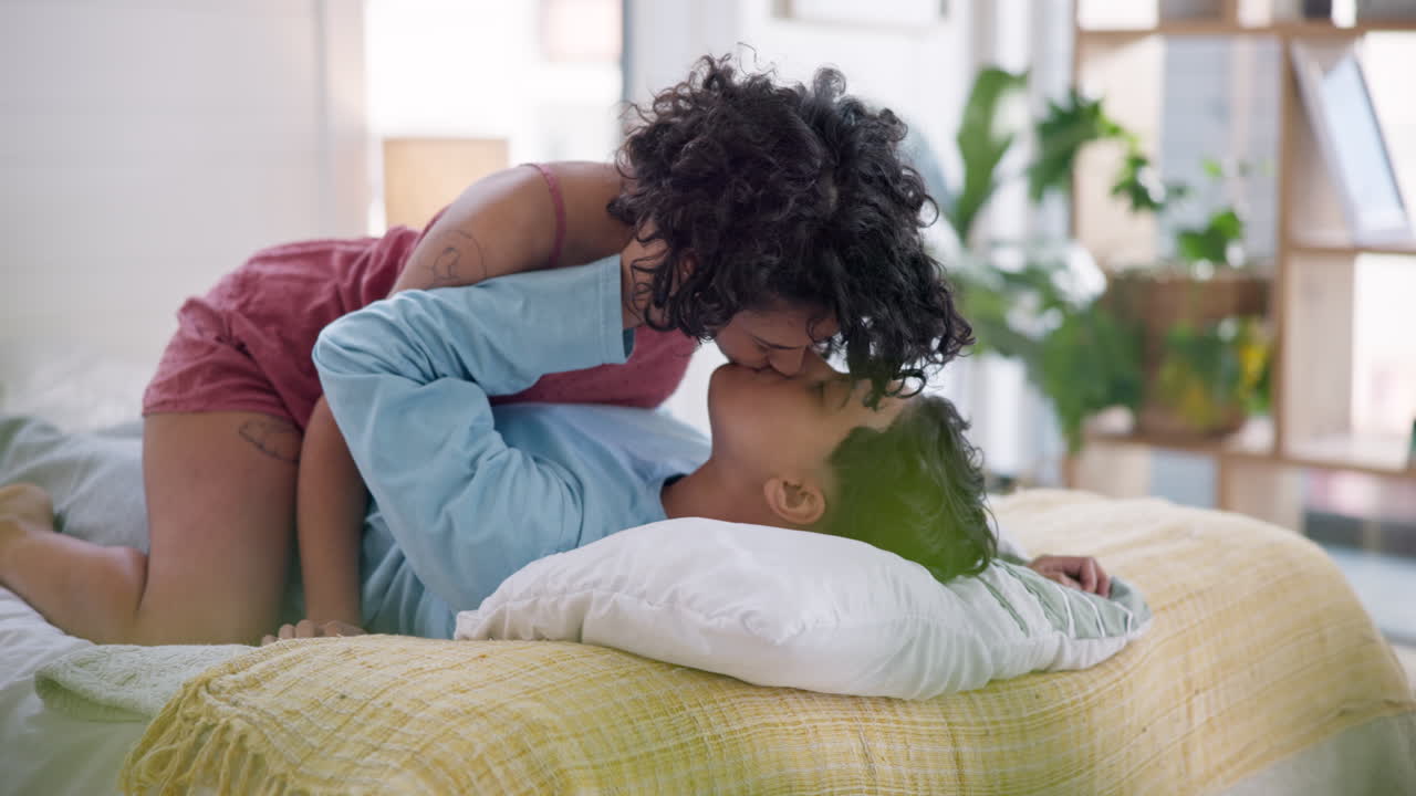 Amore, camera da letto e bacio di coppia lesbica