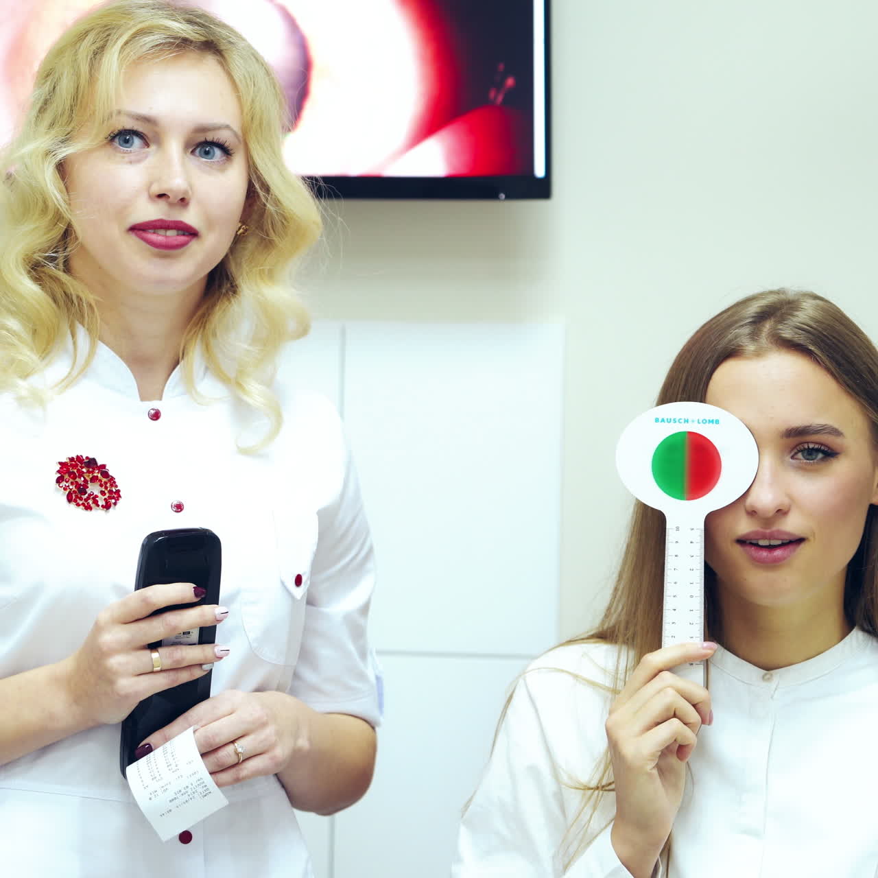 Girl checking her eyesight. Female ophthalmologist examining patient's eyes. Young woman with one eye closed doing vision test with occluder. Vision testing concept.