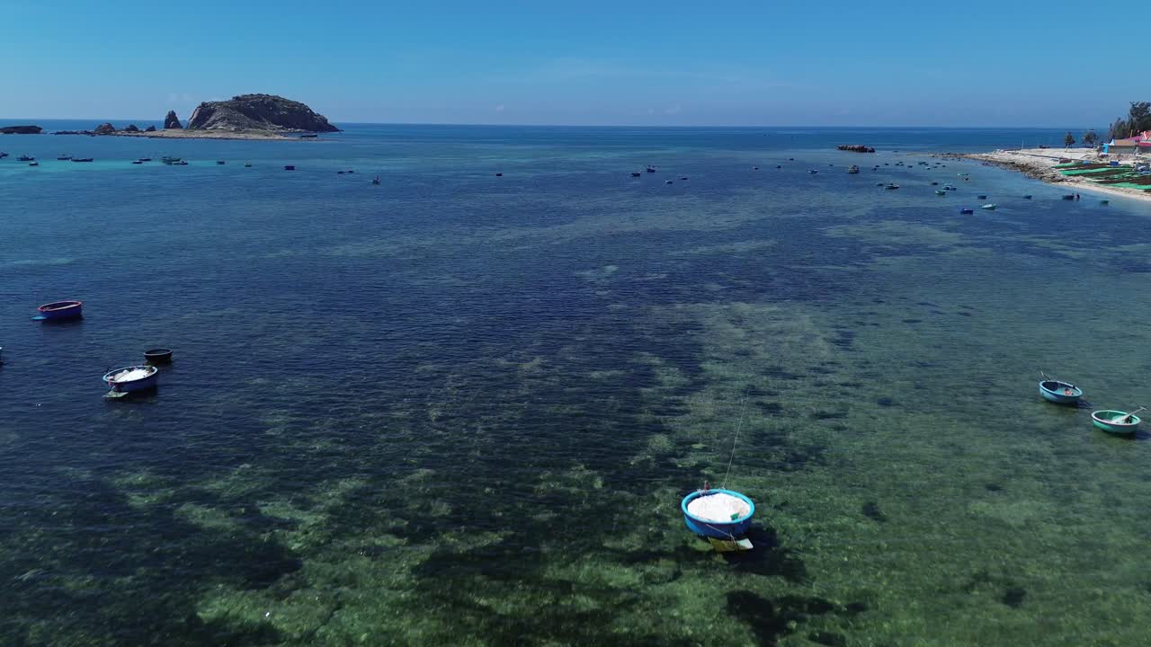 Zoom in drone shot focusing on the traditional fishing boats floating in the waters of Ninh Hải District, Ninh Thuận, Vietnam