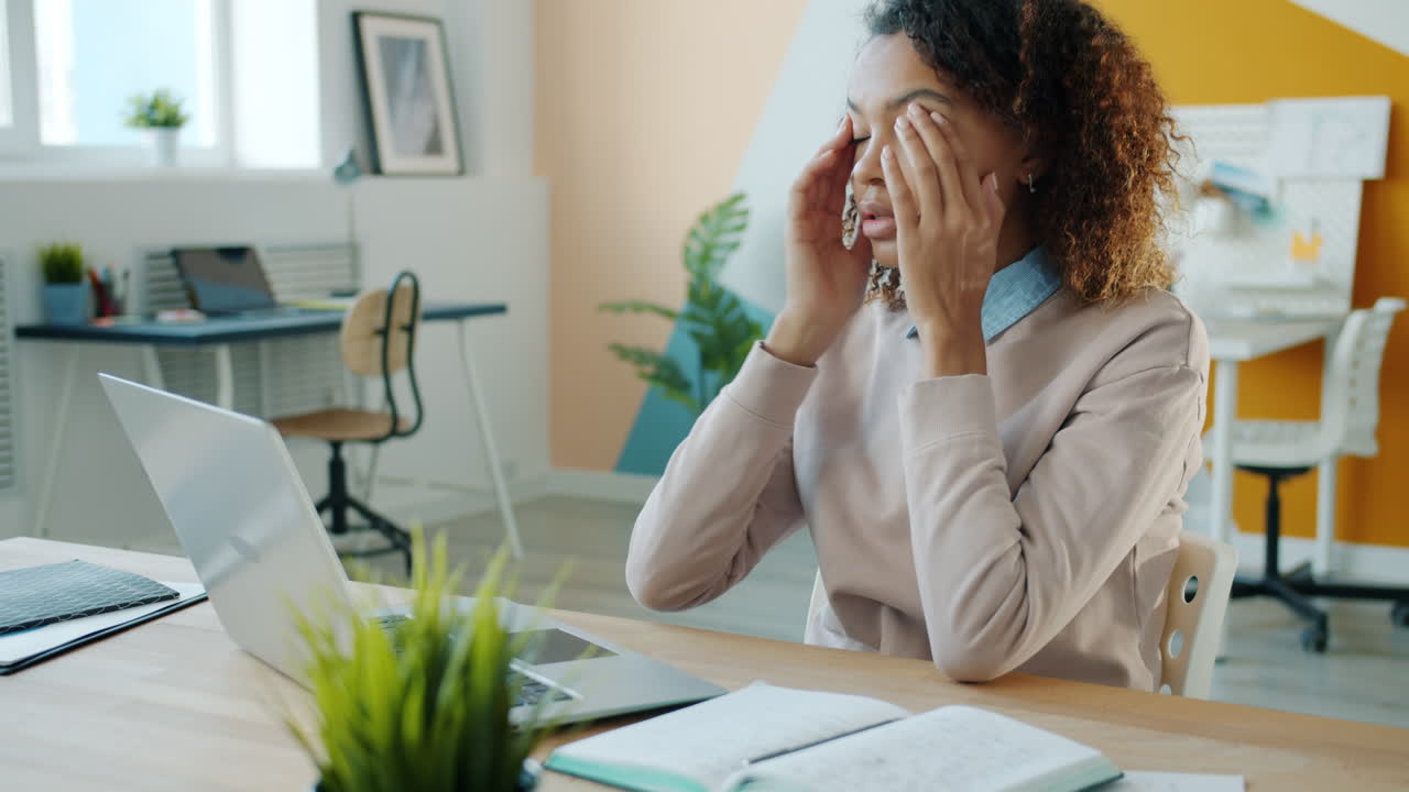 Mujer joven con dolor de cabeza en el trabajo
