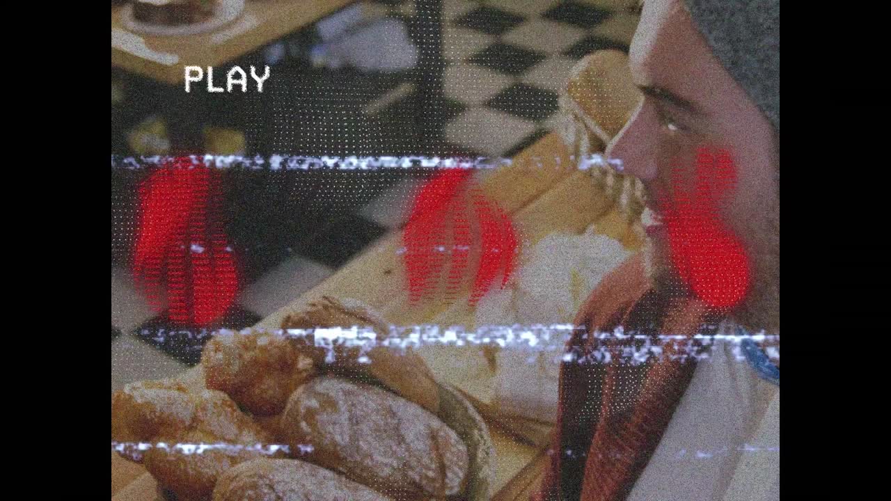 Animación de una pantalla con efecto glitch que muestra a un panadero caucásico sonriente con panes frescos en una panadería.