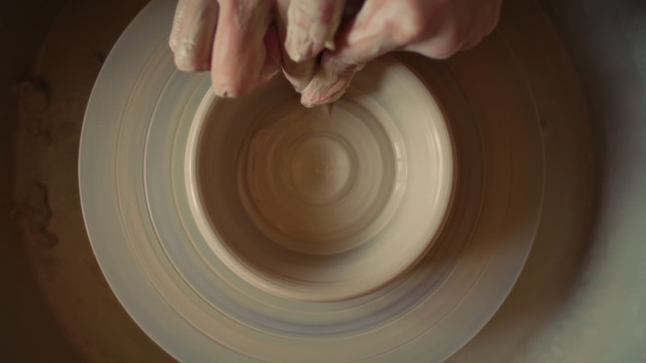 Hands of Craftsperson Forming Clay Bowl on Pottery Wheel