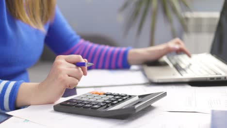 woman using calculator for calculate domestic bills at home, doing paperwork for paying taxes