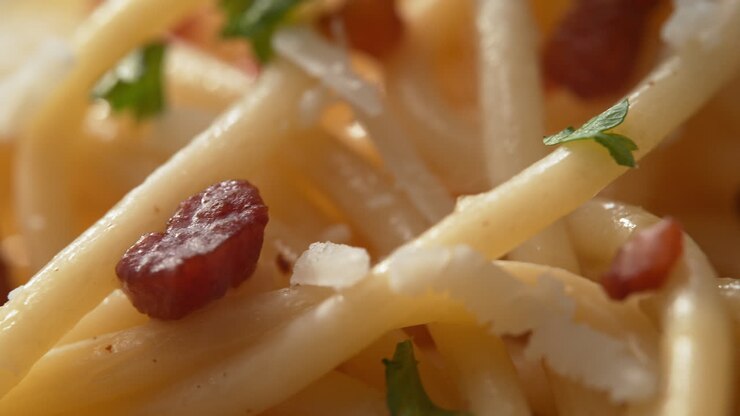 espagueti carbonara en macro - plato de vapor caliente de la cocina italiana con pancetta, queso pecorino romano rallado y hierbas picadas