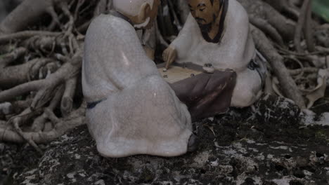 In-roots-of-a-tree-in-city-of-Hanoi-Vietnam-stands-a-porcelain-figurine