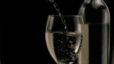 white wine being poured in super slow motion in a glass