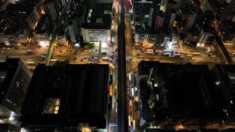 experience a stunning aerial view of a bustling city at night. bright lights illuminate the streets as vehicles navigate through traffic beneath towering skyscrapers in an urban landscape.