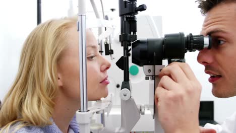 optometrista examinando a una paciente en una lámpara de hendidura