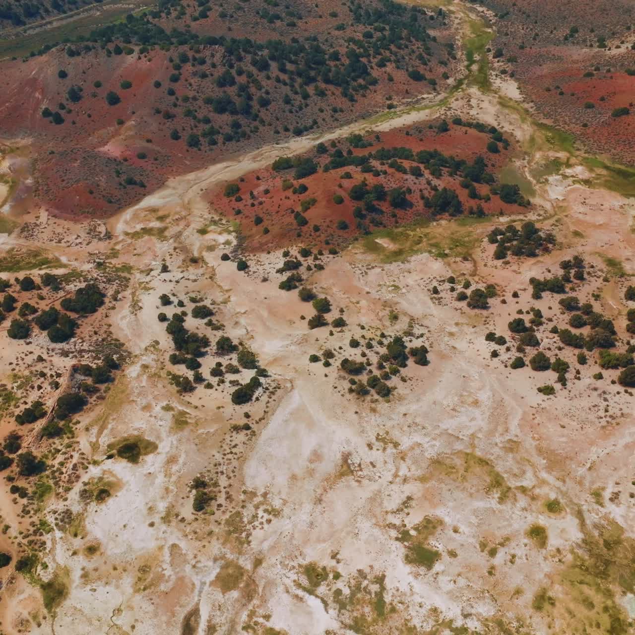 Travertine Hot Springs landscape with little greenery. Dry panorama of diverse colors from aerial perspective