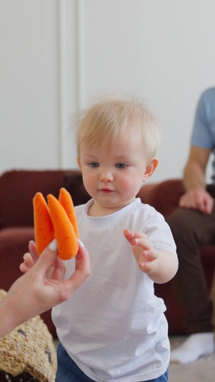 Cute Blonde Baby Playing with Soft Toys at Home