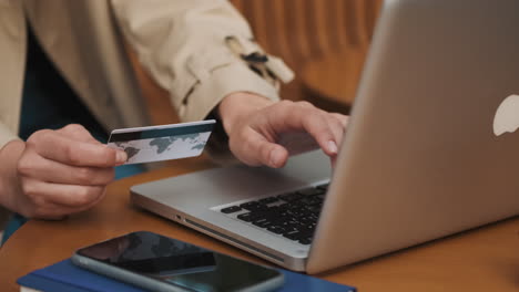 estudiante caucásica haciendo compras en línea en una computadora portátil al aire libre.