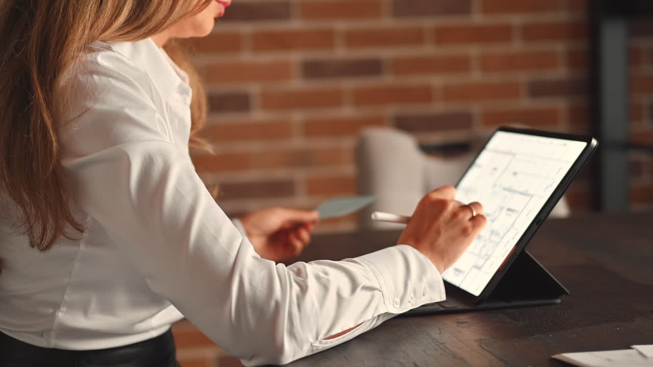 Woman working on a tablet with a stylus pen at an office