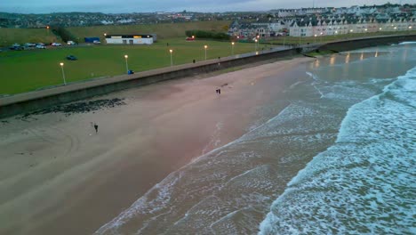 Amplia-Toma-Aérea-De-La-Playa-De-Portrush-West-Strand-Por-La-Noche