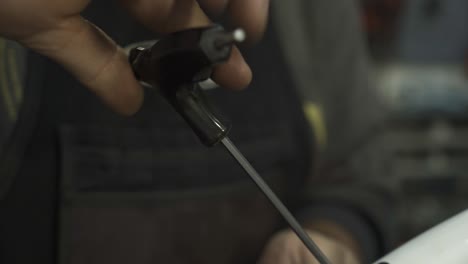 A bicycle mechanic tightening a fender screw