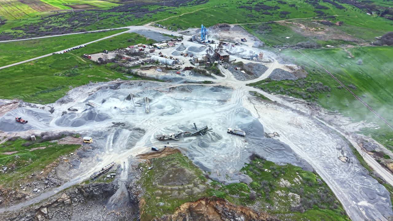 Granite quarry showing heavy machinery and stone extraction process in a rural area during the daytime
